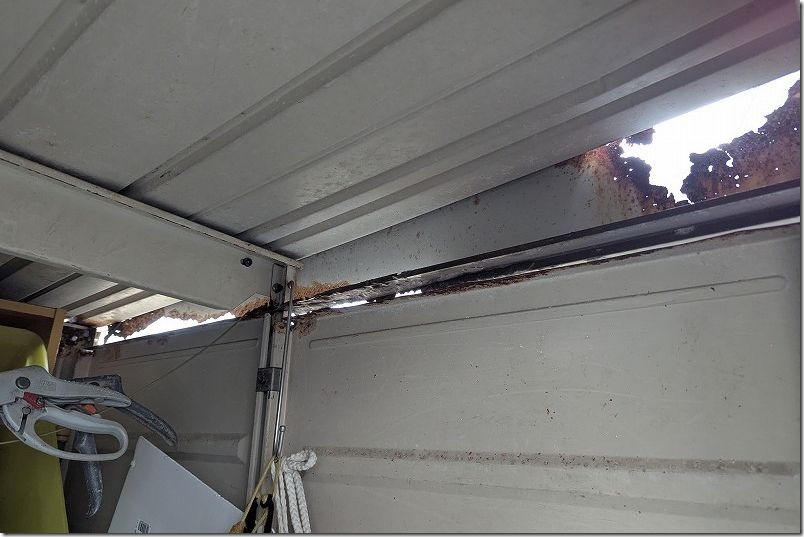 サビ落としで、物置側面の朽ちた部分は崩れ落ちて大穴が開く サビ落としで、物置側面の朽ちた部分は崩れ落ちて大穴が開く